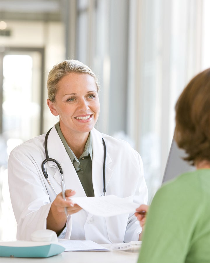 Young female doctor talking to patient