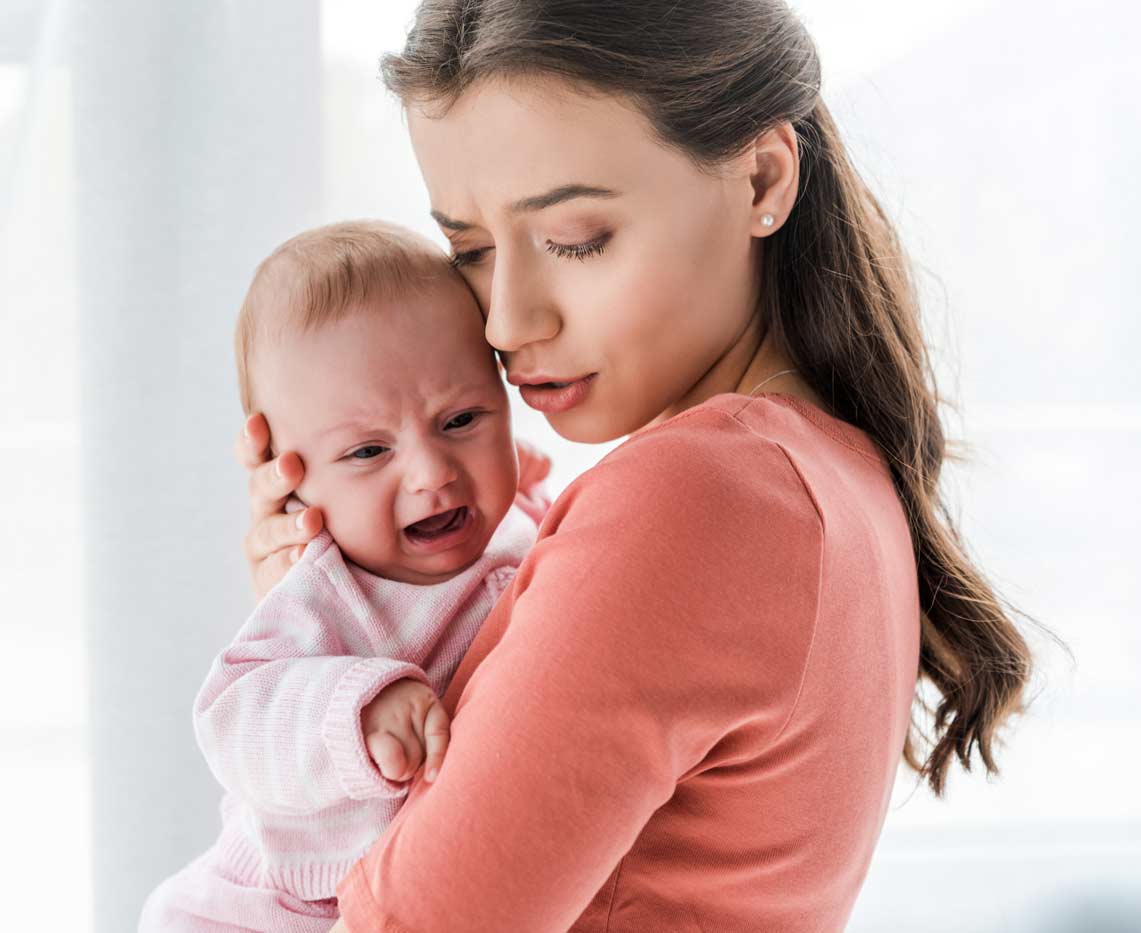 mother holding crying infant